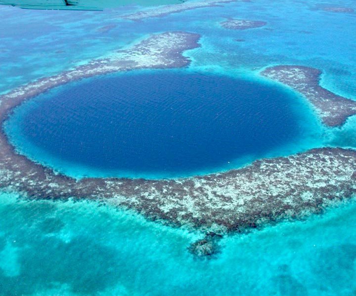 Aerial view of the Great Blue Hole surrounded by turquoise water and coral reefs